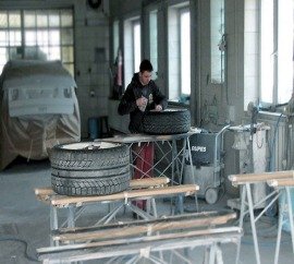 pracownik lakieruje część samochodu